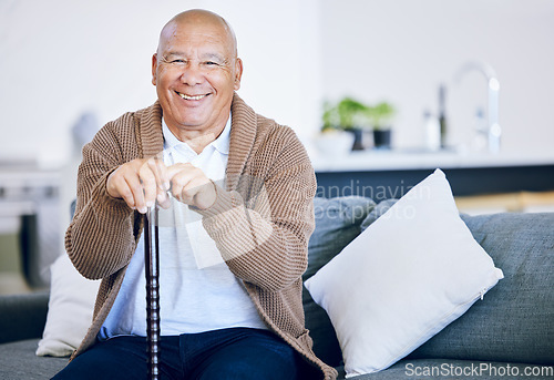 Image of Portrait, home and old man with a smile, walking stick and relax with retirement, peace and calm on a couch. Senior person in a living room, elder or pensioner on a sofa, cane or support with health