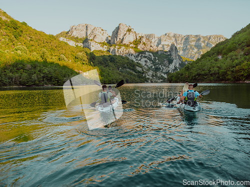 Image of A group of friends enjoying having fun and kayaking while exploring the calm river, surrounding forest and large natural river canyons