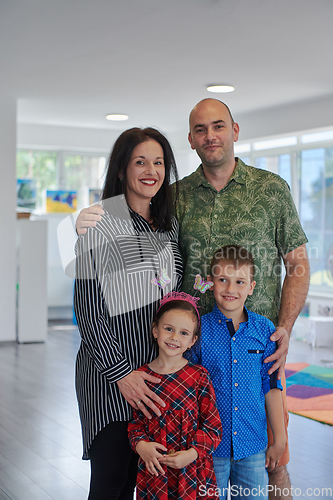 Image of Portrait of a happy family. Photo of parents with children in a modern preschool classroom. Selective focus