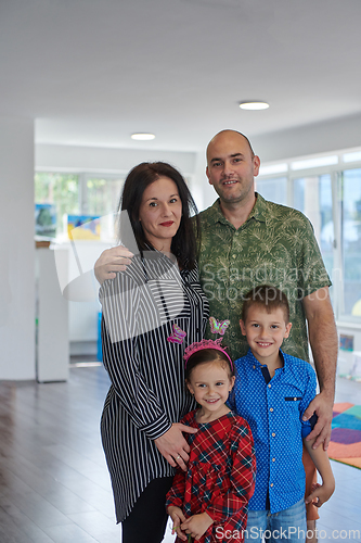 Image of Portrait of a happy family. Photo of parents with children in a modern preschool classroom. Selective focus