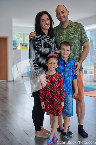 Image of Portrait of a happy family. Photo of parents with children in a modern preschool classroom. Selective focus