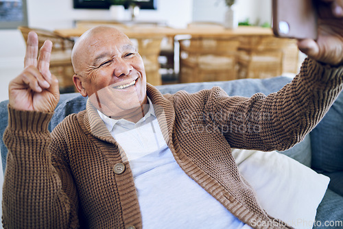 Image of Selfie, peace sign and happy senior man on sofa smile for social media, online post and profile picture. Technology, retirement and elderly person take photo with emoji, hand gesture or relax in home