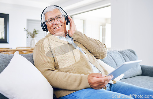 Image of Portrait, home and old man with tablet, headphones and smile with connection, streaming music and radio. Senior person, technology and pensioner with headset, listening to audio and sound on a couch