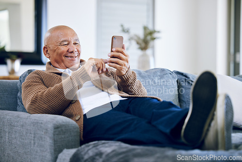 Image of Smile, relax and a senior man with a phone on the sofa for social media, contact or commmunication. Happy, online and an elderly person on the home couch with a mobile for an app or typing a chat