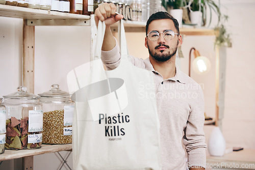 Image of Man at eco friendly grocery store, fabric shopping bag and commitment to climate change at sustainable small business. Zero waste, plastic kills logo and supermarket with carbon footprint choice.