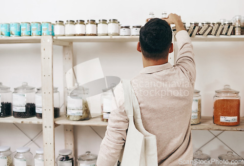 Image of Man, back and shopping by shelf in grocery store for healthy food, nutrition and wellness product sales. Choice, decision and customer nutritionist in supermarket for retail purchase, buying or deal