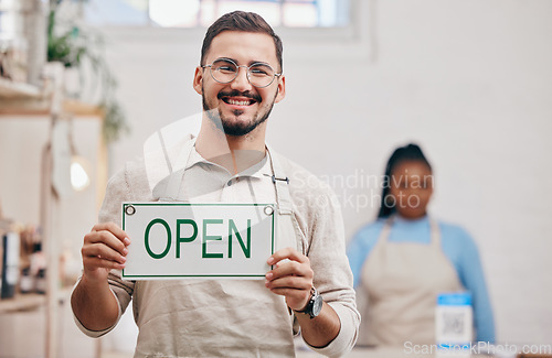 Image of Open, sign and man with small business or restaurant happy for service in a coffee shop, cafe or store with a board. Smile, manager and portrait of an entrepreneur ready for operations with billboard