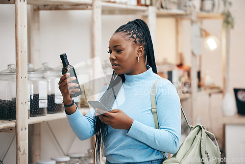 Image of Woman, shopping and phone for ingredient reading in grocery store for healthy food, nutrition and product information. Research, confused and African customer with technology for supermarket choice