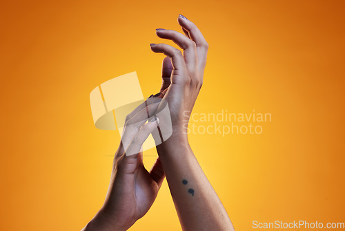 Image of Hands, touch and skin care of a woman in studio with dermatology cosmetics and a manicure. Beauty salon, spa and a person on an orange background for wellness, health and clean body or hygiene