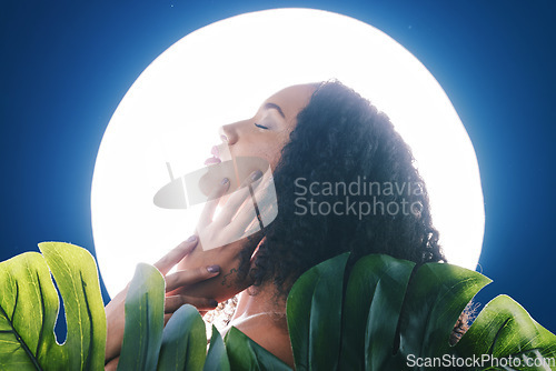 Image of Beauty, neon and face of woman with leaves for wellness, natural cosmetics and skincare in studio. Circle light, salon aesthetic and profile of person for makeup, glamour or facial on blue background