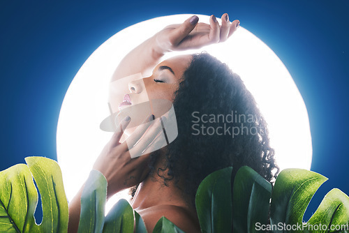 Image of Skincare, neon and face of woman with leaf for wellness, natural cosmetics and beauty in studio. Circle light, salon aesthetic and profile of person for makeup, glamour and facial on blue background