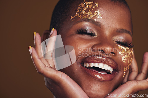 Image of Gold, laughing and woman face closeup with makeup and luxury treatment with rich spa mask. Glitter, golden dermatology and African person happy from creative skincare and art cosmetics in studio