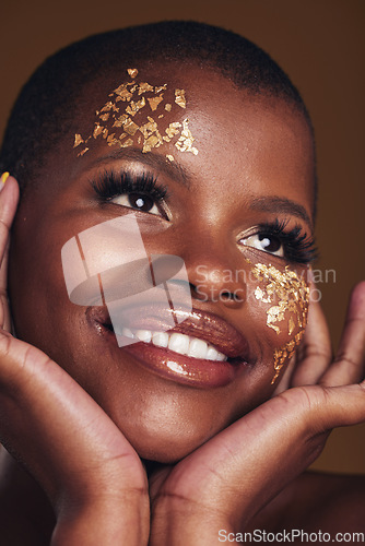 Image of Gold, makeup and woman face closeup with a smile from luxury treatment and facial spa mask. Glitter, golden dermatology and African female person happy from skincare and golden cosmetics in studio