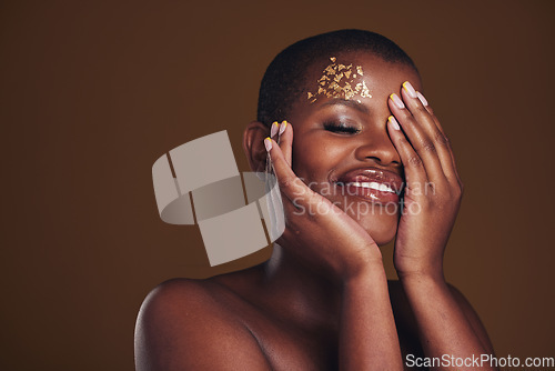 Image of Art, beauty and black woman with gold makeup on brown background, glitter paint and cosmetics mockup. Shine, glow and African model in studio space for fashion, aesthetic freedom and luxury skincare.