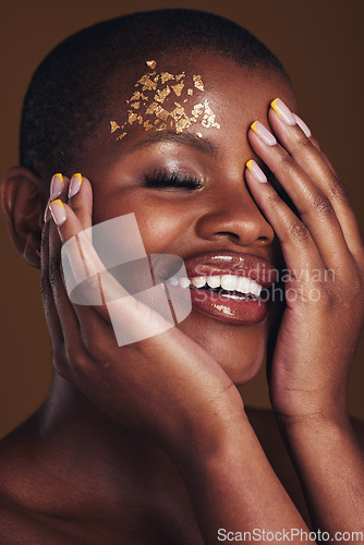 Image of Art, cosmetics and black woman with gold makeup on brown background, glitter paint and beauty. Shine, glow and African model in studio for fashion inspiration, aesthetic freedom and luxury skincare.