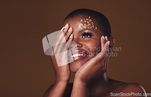 Image of Art, smile and black woman with gold makeup on brown background, glitter and cosmetics mockup. Beauty shine, glow and African model in studio space for fashion, aesthetic freedom and luxury skincare.