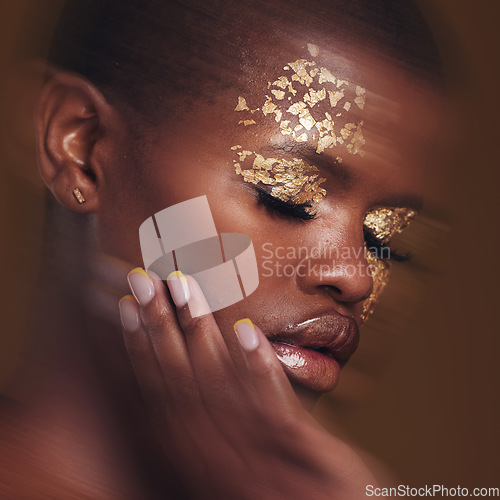 Image of Gold beauty, blur and black woman with hand on face closeup with makeup and cosmetics in studio. Brown background, African female model and manicure with golden shine and glow from paint sparkle