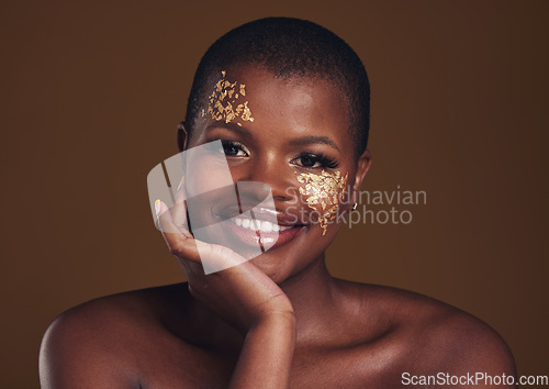 Image of Gold, glitter portrait and black woman beauty with makeup and skincare mask in studio with sparkle cosmetics. Brown background, funny and model with golden paint for skin glow and creative shine