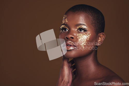 Image of Art, mockup and black woman with gold makeup on brown background, glitter paint and cosmetics. Shine, glow and African model in studio for beauty, fashion and aesthetic freedom in luxury skincare.