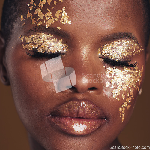 Image of Gold, art and black woman with makeup for beauty aesthetics isolated in a studio brown background eyes closed. Creative, luxury and face of African person with cosmetic glamour or design for skincare