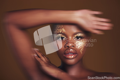 Image of Art, portrait of black woman with gold makeup and blurred background, glitter paint and cosmetics. Shine, glow and African model in studio for beauty, fashion and aesthetic freedom in luxury skincare