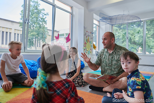 Image of Reading time in an elementary school or kindergarten, a teacher reading a book to children in an elementary school or kindergarten. The concept of pre-school education. Selective focus