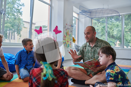 Image of Reading time in an elementary school or kindergarten, a teacher reading a book to children in an elementary school or kindergarten. The concept of pre-school education. Selective focus