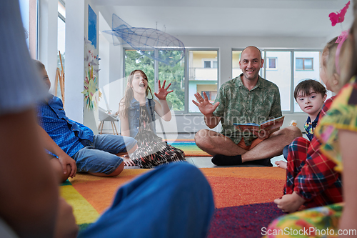 Image of Reading time in an elementary school or kindergarten, a teacher reading a book to children in an elementary school or kindergarten. The concept of pre-school education. Selective focus