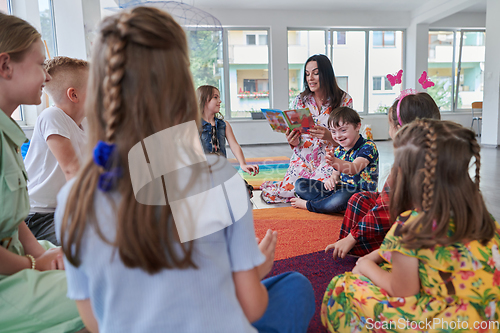 Image of Reading time in an elementary school or kindergarten, a teacher reading a book to children in an elementary school or kindergarten. The concept of pre-school education. Selective focus