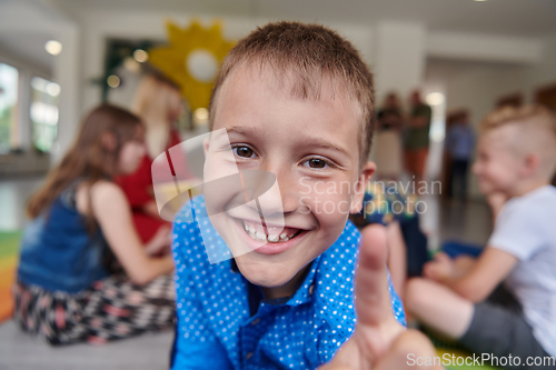 Image of Portrait photo of a smiling boy in a preschool institution having fun