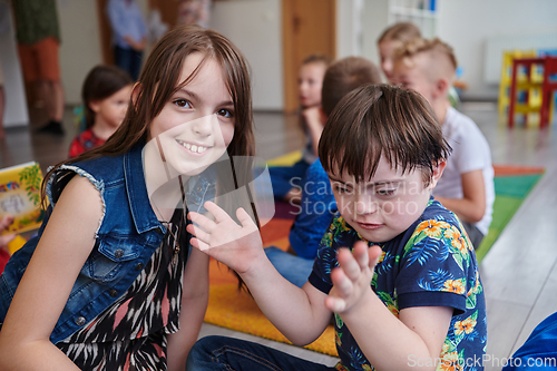 Image of A girl and a boy with Down's syndrome in each other's arms spend time together in a preschool institution