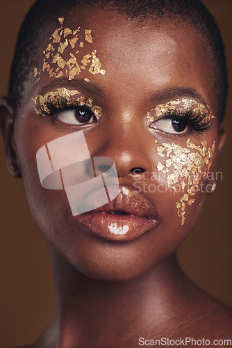 Image of Art, face of black woman with gold makeup and brown background, glitter paint and cosmetics. Shine, glow and African model in studio on facial beauty, fashion and aesthetic freedom in luxury skincare