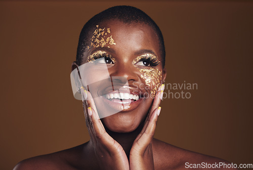 Image of Gold, glitter face and black woman beauty with makeup and smile in studio with sparkle cosmetics. Brown background and female model with golden paint for skin glow art and creative facial shine