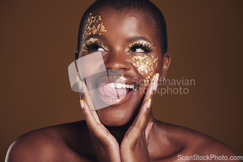 Image of Gold, glitter face and black woman beauty with makeup and tongue out in studio with sparkle cosmetics. Brown background, funny and female model with golden paint for skin glow and creative shine