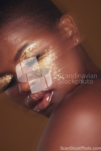 Image of Gold beauty, blurred and black woman with eye makeup closeup with cosmetics in studio. Brown background, African female person and glitter with golden shine and glow from facial paint sparkle