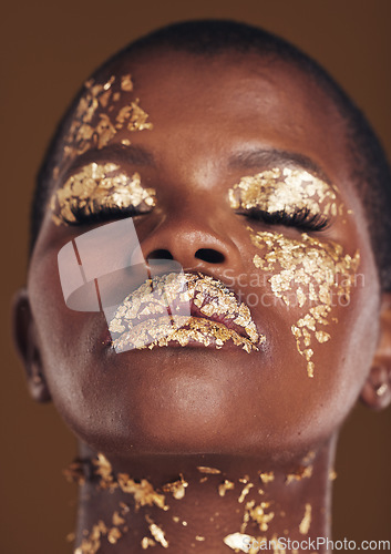 Image of Gold, art and face of black woman with makeup for beauty aesthetics isolated in a studio brown background eyes closed. Creative, luxury and African person with cosmetic glamour or design for skincare