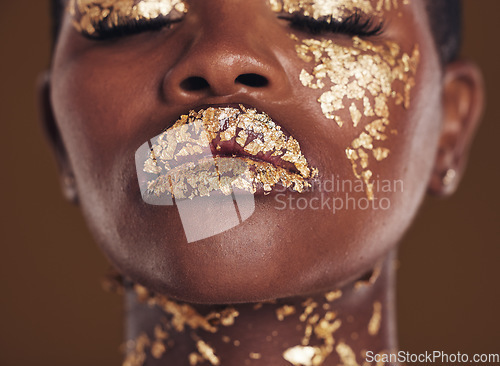 Image of Gold, creative and face of black woman with makeup for beauty aesthetics isolated in a studio brown background eyes closed. Art, luxury and African person with cosmetic glamour or design for skincare