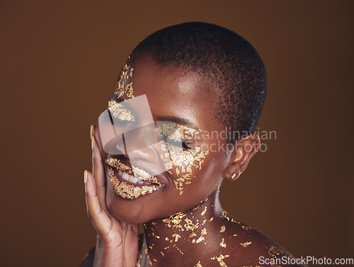 Image of Black woman, relax and gold makeup with luxury dermatology and skincare mask with glitter. Sparkle, smile and beauty with happy glow and shine of cosmetics and model in a studio with facial art
