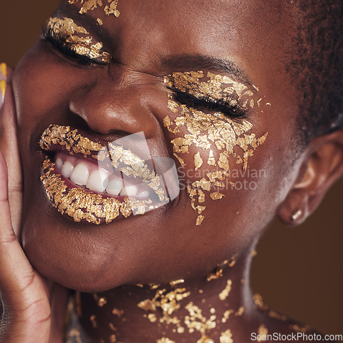 Image of Black woman, face and gold makeup closeup with luxury dermatology and skincare mask with glitter. Sparkle, smile and beauty with rich and shine of cosmetics and model in a studio with facial art