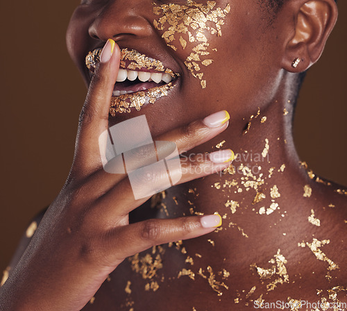 Image of Gold, smile and woman mouth closeup with makeup and luxury treatment with rich spa mask. Glitter, golden dermatology and African person happy from creative skincare and art cosmetics in studio