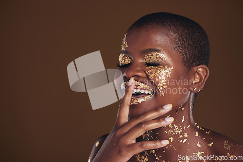 Image of Happy laugh of black woman with gold makeup, mockup on brown background and glitter paint for cosmetics. Shine, glow and smile, African model in studio for facial beauty and funny aesthetic luxury.