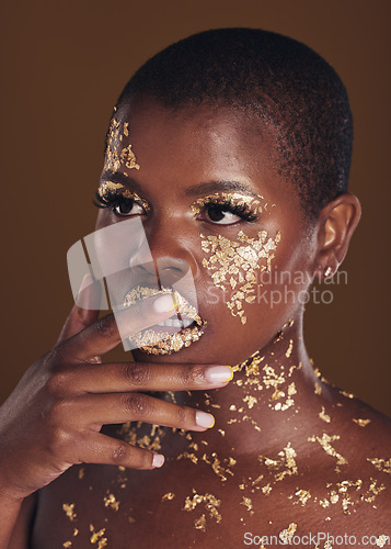 Image of Beauty, black woman with gold paint makeup and brown background with glitter, art and cosmetics. Shine, glow and face of African model in studio for skincare, aesthetic and luxury facial with color.