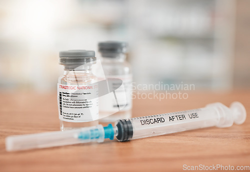 Image of Pharmacy, syringe and vial in vaccine for medication, illness or cure in healthcare on table. Drugs, needle and pharmaceutical product on desk for vaccination, flu shot or equipment at clinic store