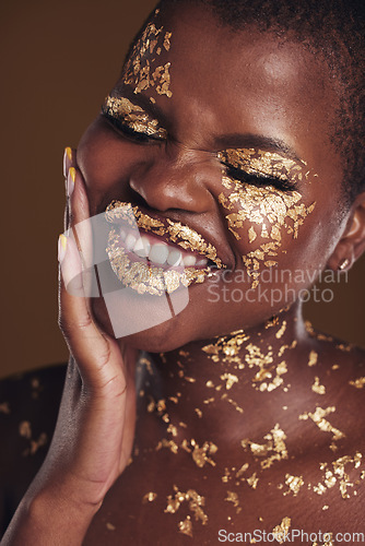 Image of Black woman, silly face and gold makeup with luxury dermatology and skincare mask with glitter. Sparkle, smile and beauty with rich and shine of cosmetics and model in a studio with facial art