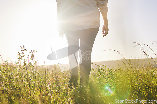 Image of Back, sunrise and a woman walking on a farm for sustainability or growth in the morning with flare. Farming, agriculture and female farmer on a nature landscape for eco friendly harvesting in season