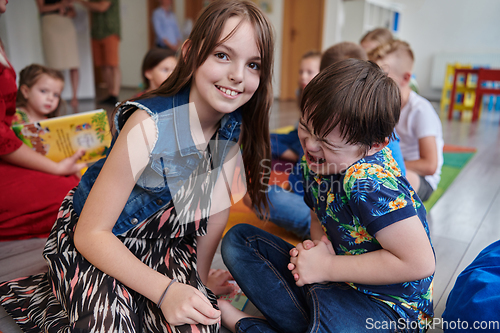 Image of A girl and a boy with Down's syndrome in each other's arms spend time together in a preschool institution