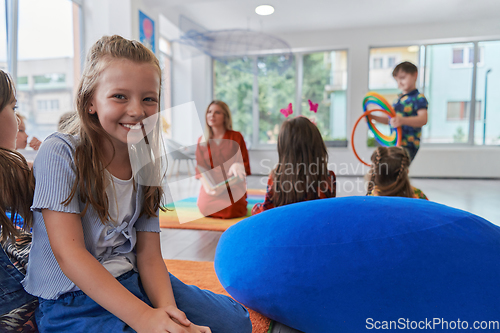 Image of Reading time in an elementary school or kindergarten, a teacher reading a book to children in an elementary school or kindergarten. The concept of pre-school education. Selective focus