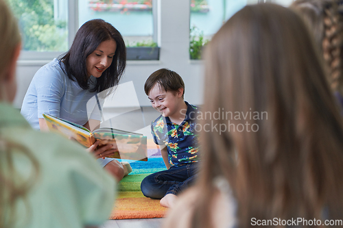 Image of Reading time in an elementary school or kindergarten, a teacher reading a book to children in an elementary school or kindergarten. The concept of pre-school education. Selective focus