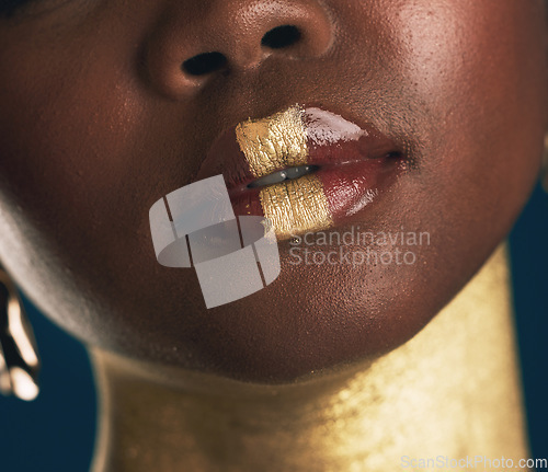 Image of Closeup, lips and woman with makeup, creative and beauty on a dark studio background. Zoom, person and model with fine art, mouth and facial cosmetics with colorful skin art and aesthetic with gold