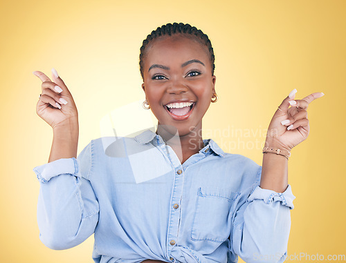 Image of Portrait, dance and celebration with an excited black woman on a yellow background in studio looking happy. Smile, energy or surprise and a young person cheering for success or bonus with motivation